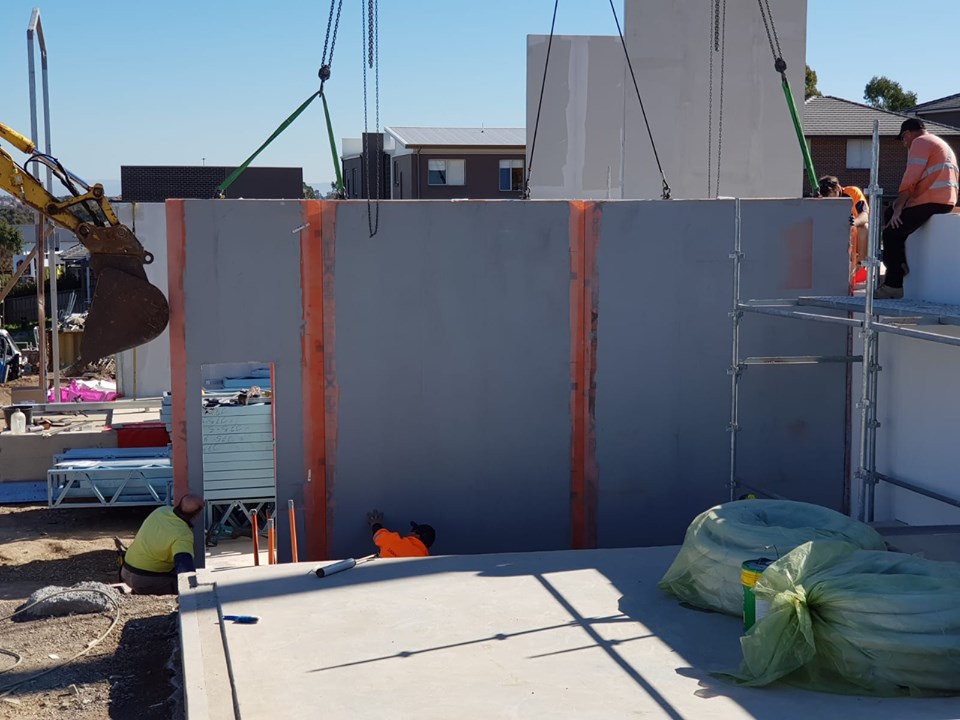 Rock Max panels being installed by crane with workers perfecting fitment.