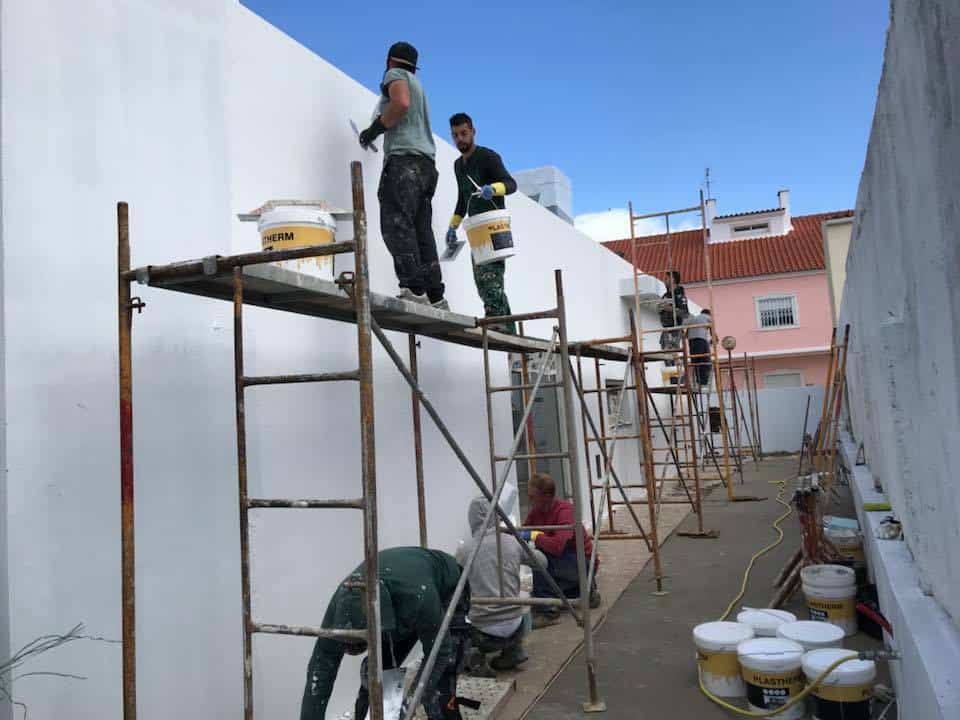 Construction workers on scaffolds installing Rock Max MGO sheets.